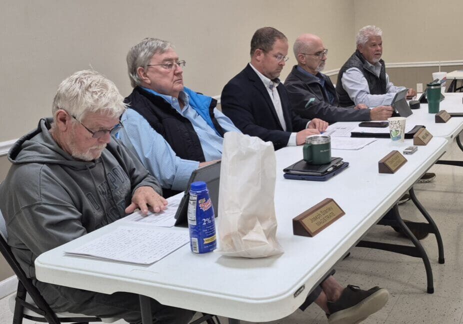 Five men sitting at a conference table.