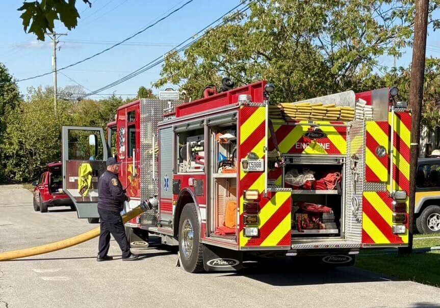 Firefighter with fire truck on sunny day.