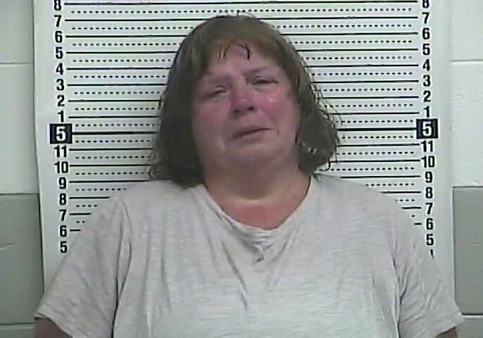 A woman in front of height chart.