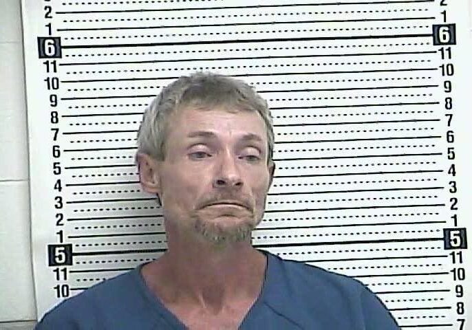 Man in front of height measurement chart.