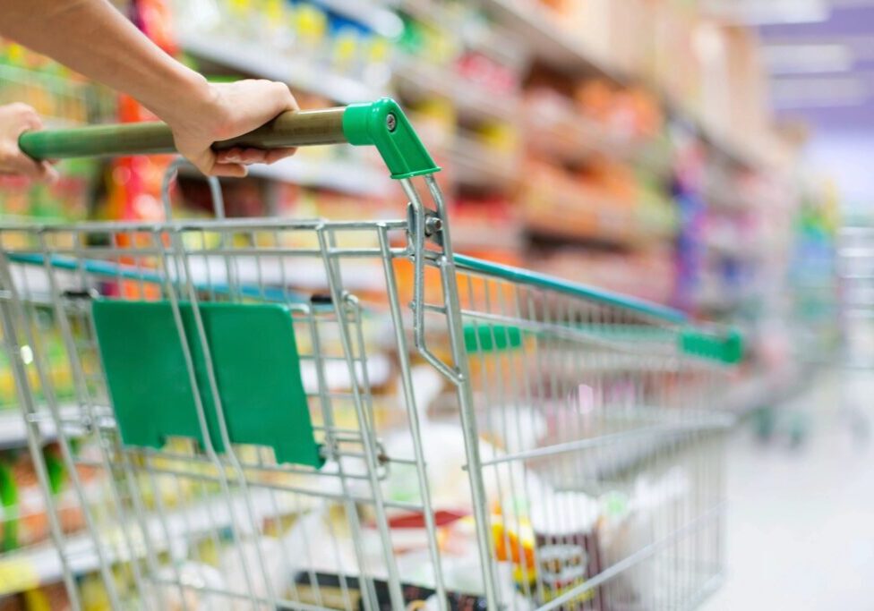 Shopping cart in a grocery store aisle.