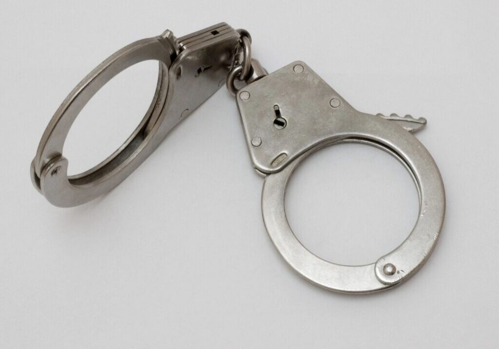 Silver handcuffs on a white background.