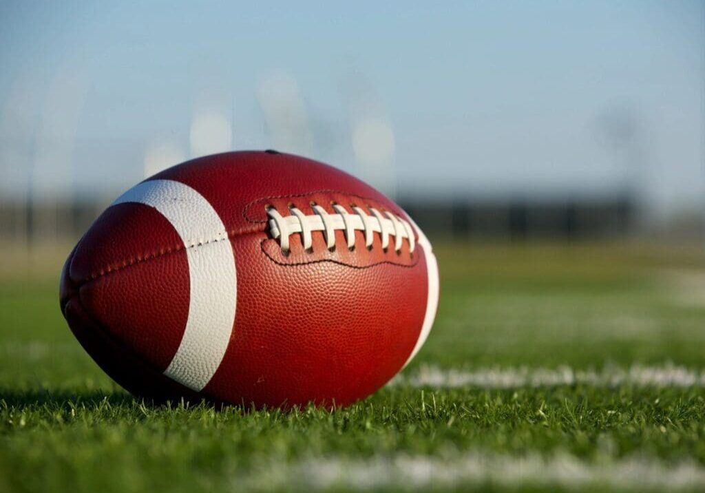 American football on grassy field.