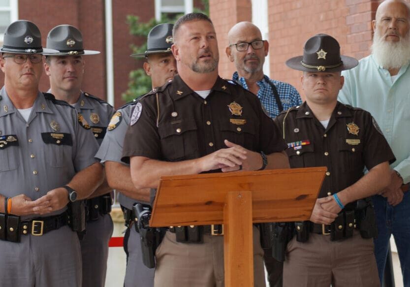 Police officers and officials at a podium.