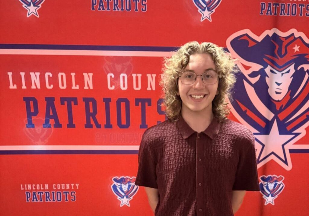 Person standing before Lincoln County Patriots banner.