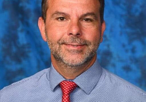 Man in blue shirt and red tie.